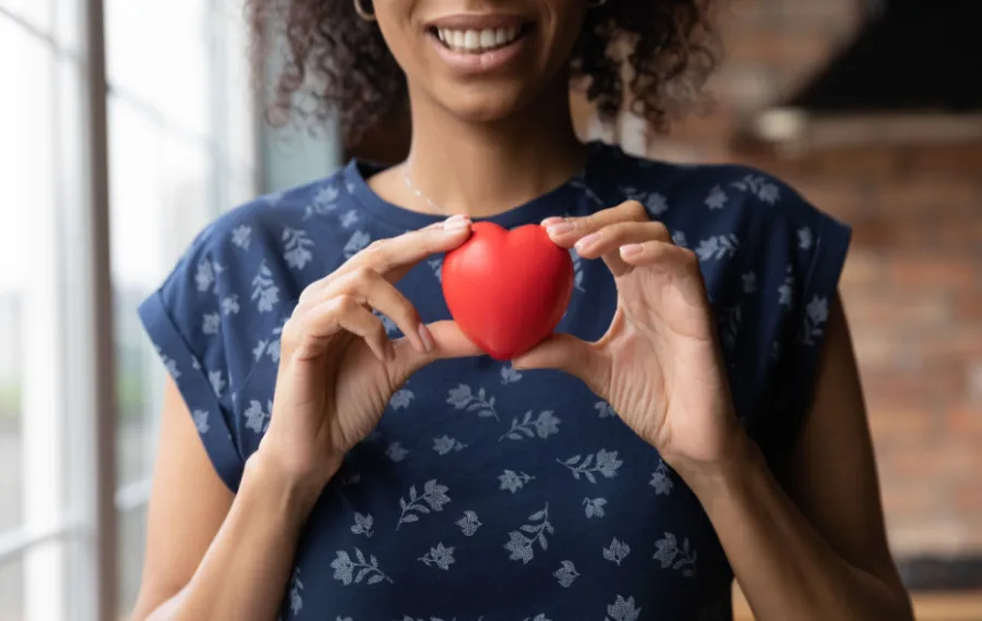 A woman holding a heart shows the concept of insurance for drug rehab Albuquerque