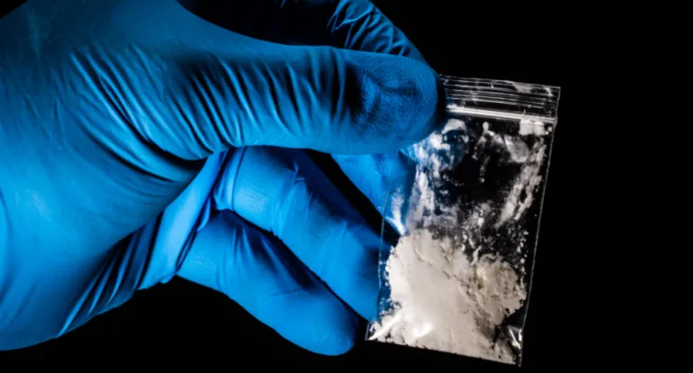 Baggie of powder held by gloved hand shows the need for fentanyl detox near me in New Mexico