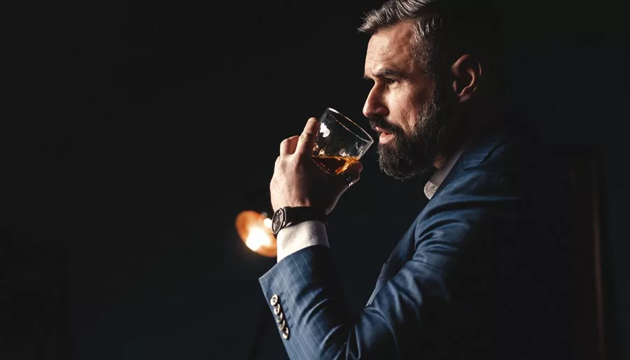 Am I an Alcoholic Quiz - Man with beard holds glass of Alcohol