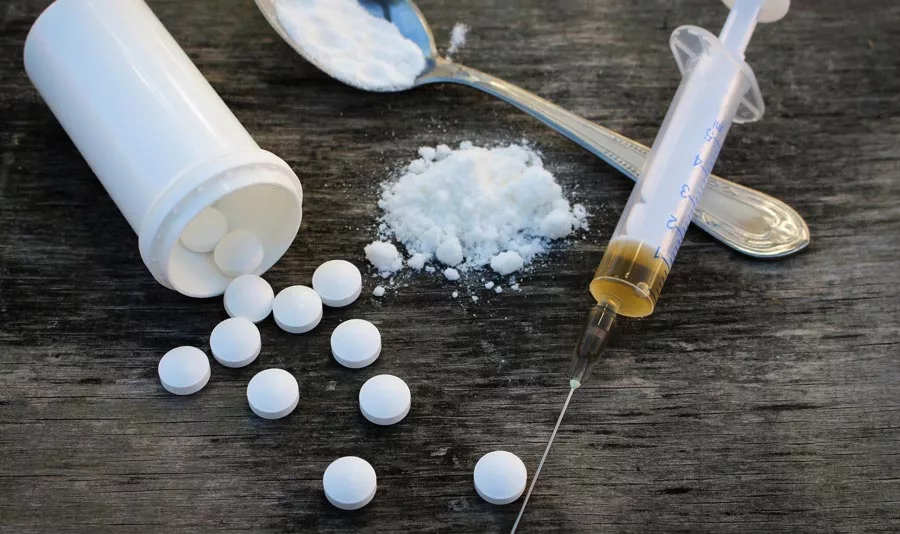 White Heroin Pills, syringe and heroin on spoon