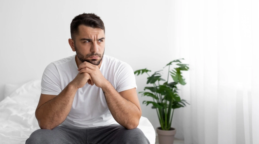 Man sitting alone looking bewildered - Anxiety - Long-term Effects of PTSD