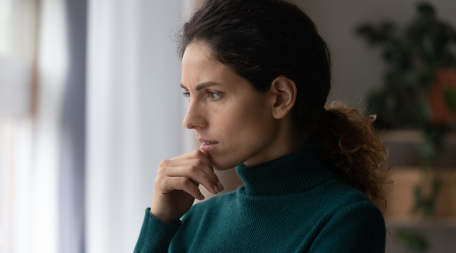 Woman with hand on her chin looking pensive - Dissociative Amnesia - Memory Loss Caused by Trauma