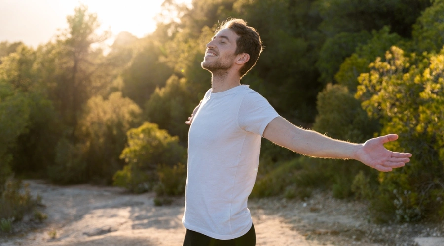 Man standing outside smiling with has hands and harms extended fully out - Healthy Lifestyle - Safe and Effective Alcohol Tapering Strategies