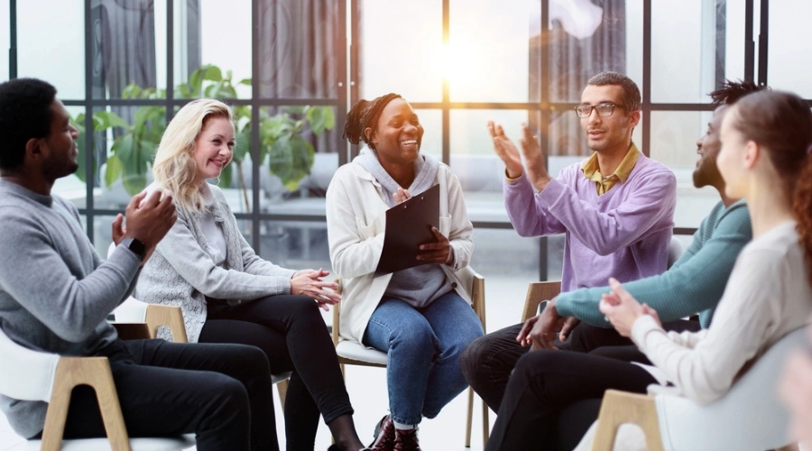Persons happily sitting in group therapy session - Living with PTSD as a Disability - Support Networks