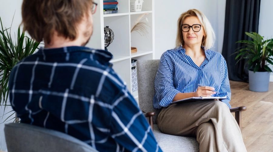 Counselor sitting in a chair talking to patient beside her - Reliable Treatment Provider