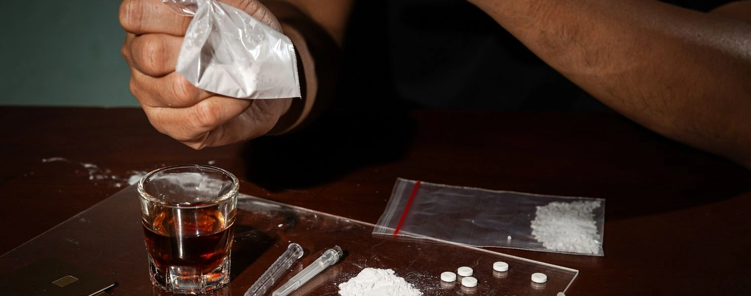 Image of various drugs on a table - What Is Active Addiction - Icarus Behavioral Health