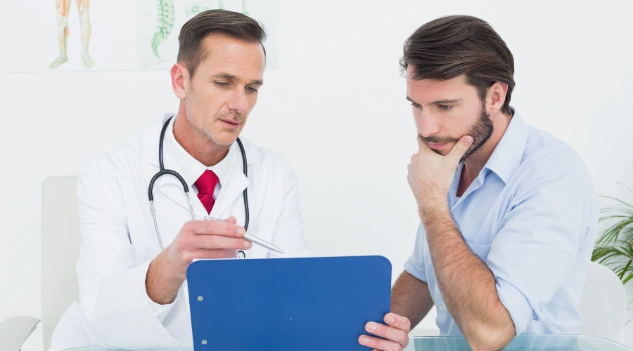Image of a Healthcare professional reviewing New Mexico Medicaid insurance with a male patient who is looking on